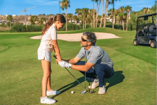 coach helps to learn the basics of golf