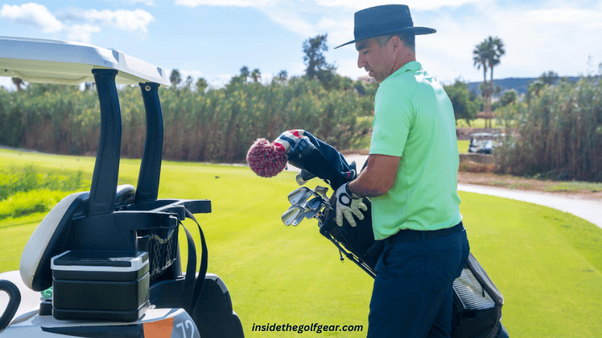 Man playing golf picking up the club after the release in the club bag and placing it in the buggy